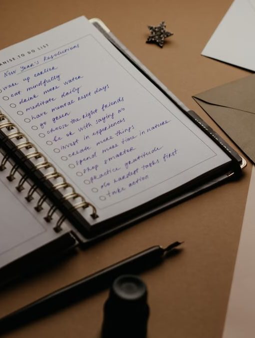 A tidy desk setup featuring a planner, to-do list, envelopes, and a pen.